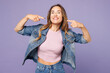 © ViDi Studio - Young smiling happy woman she wear denim jacket violet top casual clothes point index finger on opened mouth show white teeth isolated on plain pastel light purple background studio Lifestyle concept