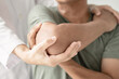 © Orathai - Female physiotherapists provide assistance to male patients with elbow injuries examine patients in rehabilitation centers. Physiotherapy concepts