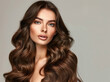 © Milla - Fashionable fashion woman with elegance makeup, long shiny curly hairstyle and healthy skin against gray studio wall background