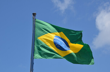 Flag of Brazil fluttering in the wind. In the center of the flag with the words 