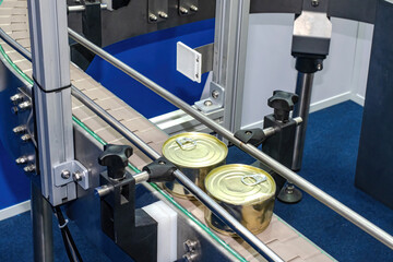 Poster - Conveyor with cans. Food production line. Conveyor for packaging canned products. Production line close up. Automated production of canned fish. Conveyor manufacturing of goods. Food fabrication