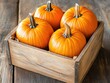© AkuAku - Ripe pumpkins in a wooden box on a wooden background with a harvest theme flat lay