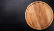 © Uuganbayar - Top view on empty wooden round cutting board on black background with copy space. Restaurant menu or recipe mockup.