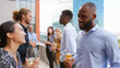 © Monkey Business - Multi-Cultural Business Team Meeting Outdoors For After Work Drinks On Office Rooftop Or Bar