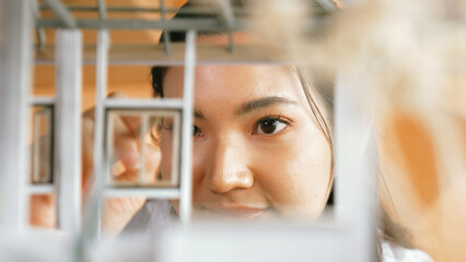 Closeup portrait of architect engineer face reviewing house model while inspect building construction. Project manager checking house model. Business design concept. Focus on face. Manipulator.