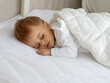 © niwat - Baby boy sleeping in white bed