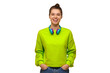 © Damir Khabirov - Happy woman in green neon sweatshirt, wearing wireless headphones around neck, keeping hands in pockets