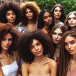 © fitpinkcat84 - Diverse women with different natural hairstyles, including curly, wavy, and braided hair. Group portrait showcasing beauty and individuality, outdoor setting with natural lighting