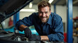 © yurakrasil - A mechanic is smiling while working on a car engine