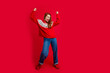 © deagreez - Photo of young energetic redhair lady dancing wearing seasonal sweater and jeans have fun xmas discotheque isolated on red color background
