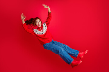 Sticker - Full body portrait of young nice woman fly fall christmas isolated on red color background