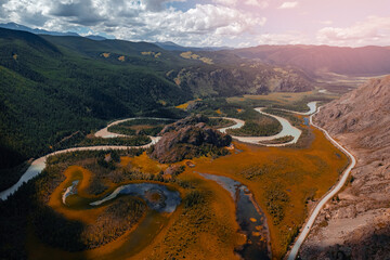 winding river meander in mountains with forest trees with sunlight, top view. beautiful aerial lands