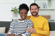 © New Africa - International relationships. Portrait of lovely couple on sofa at home