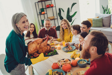 Poster - Photo of cheerful big family celebrating thanksgiving day together serving main dish stuffed turkey indoors