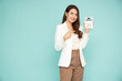 © comzeal - Portrait of happy Asian woman holding calculator isolated on green background, Custodian and financial concept