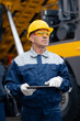 © Parilov - Coal mining worker use tablet computer on background big yellow truck