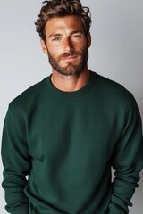  A bearded man in a green sweater gazes seriously into the camera