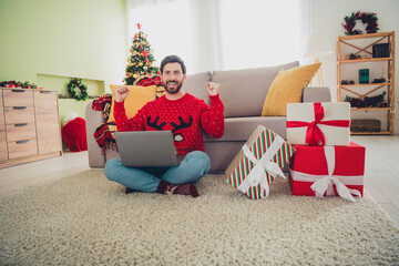 Canvas Print - Full body portrait of nice young man raise fists use laptop christmas holiday time flat indoors