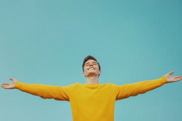 Canvas Print - A man is shown with his arms spread wide, wearing a bright yellow sweater