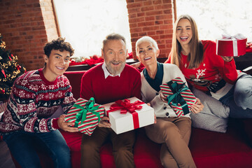 Wall Mural - Portrait of four family members sit couch hold show giftbox xmas new year enjoyment home flat indoors