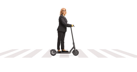 Poster - Middle aged woman riding an electric scooter at a pedestrian zebra crossing