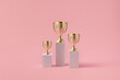 © Yaroslav Danylchenko/Stocksy - Three different podiums with shiny goblets on tops