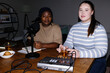 © Oleksii Syrotkin/Stocksy - Flash photo of female content makers creating podcast at home office