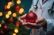 © Kateryna - Merry Christmas from doctor, hands with xmas ball on blurred light and tree