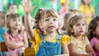 © ProPhotos - A class full of children and one little girl raises her hand. The background is blurred.