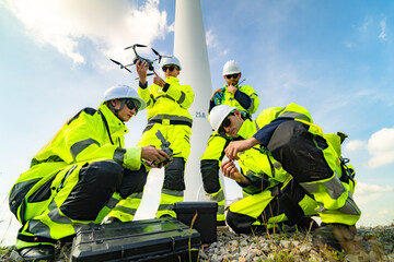 Electric engineer wearing Personal protective equipment working at wind turbines farm .  Wind turbine technicians doing wind turbine blade inspection with drone.