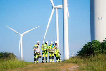 Electric engineer wearing Personal protective equipment working at wind turbines farm .  Wind turbine technicians doing wind turbine blade inspection with drone.