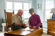 © Raymond Forbes LLC/Stocksy - Senior Veteran family Great Grandfather with Grandson look at photos