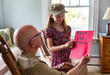 © Raymond Forbes LLC/Stocksy - Young Girl hands card portrait thanking veteran tribute at home