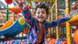 © evgenia_lo - Happy child playing in an indoor ball pit, arms wide open.