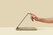 © Yaroslav Danylchenko/Stocksy - Person pushing down display of laptop standing on light surface