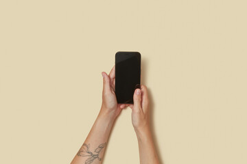 Turned off cellular phone laying between two arms of anonymous human