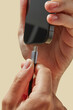 © Yaroslav Danylchenko/Stocksy - Mobile device with black display and cable over studio background