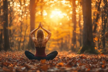 Woman practicing yoga in a serene autumn forest at sunset, focusing on mindfulness and wellbeing.