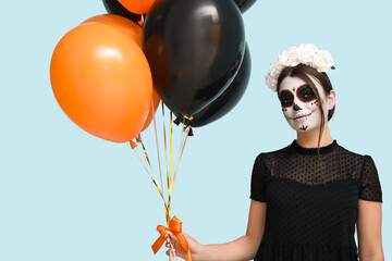 Canvas Print - Young woman dressed for Halloween with balloons on blue background