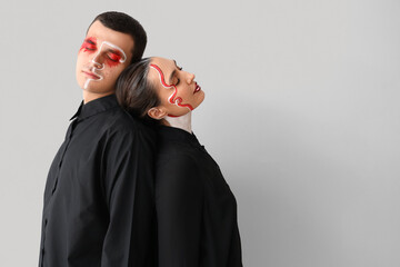 Canvas Print - Young couple with painted faces on light background