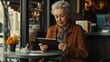 © NickArt - A confident older woman in stylish clothes sitting at a café, using a tablet and enjoying her time