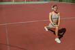 © Viktoria Kovalchuk - A young and active woman is engaged in physical exercise on an outdoor court setting