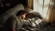 © Morng - A person rests peacefully in bed, bathed in soft morning light streaming through a window, creating a cozy and tranquil atmosphere.