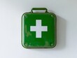 © Sinechana - 2408 133.A bright green first aid sign featuring a prominent white cross is fixed to a pristine white wall. Directly beneath it, a well-organized green medicine kit is neatly hung, its sleek design