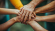 © Katrin_Primak - A group of multiethnic hands holding each other in support and unity. The concept of teamwork, community, or friendship