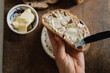 © Adrian Cotiga/Stocksy - Generous spread of butter on a rustic bread slice.