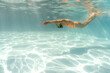 © Andriy Bezuglov/Stocksy - Woman swims underwater during her training in pool