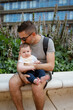 © Mauro Grigollo/Stocksy - Man holds his son while sits in a bench in the city