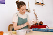 © Tania Cervian/Stocksy - Woman carefully sculpting clay cup near pottery wheel