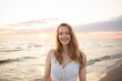 © Hernandez & Sorokina/Stocksy - Smiling woman portrait in the beach